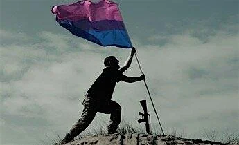 Person plants the flag for bisexual people in the ground