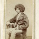 Black and white photograph of a seated black man