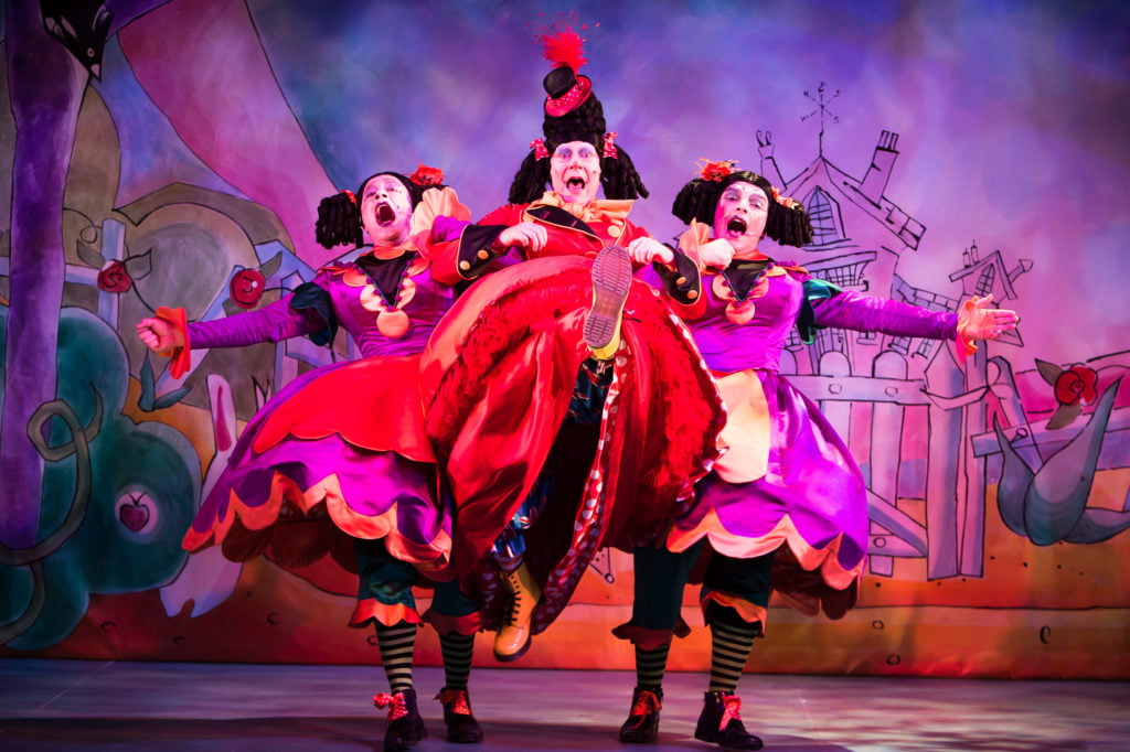 Cinderella performed at Oldham Coliseum in 2012 with 3 actors dancing and singing in bright red and purple dresses.